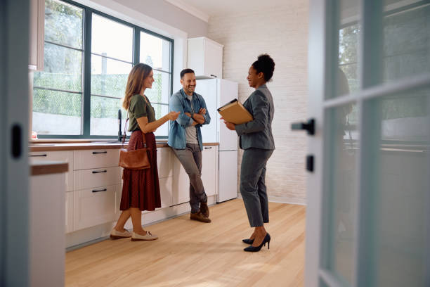 Happy couple and real estate agent in a new house kitchen